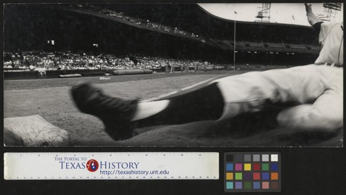 A baseball player slides into third base